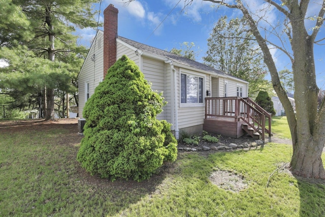 view of property exterior featuring central air condition unit, a yard, and a chimney