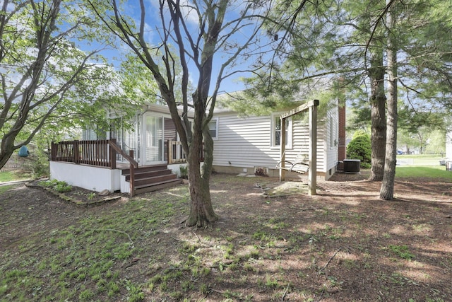 view of yard with central AC unit and a deck
