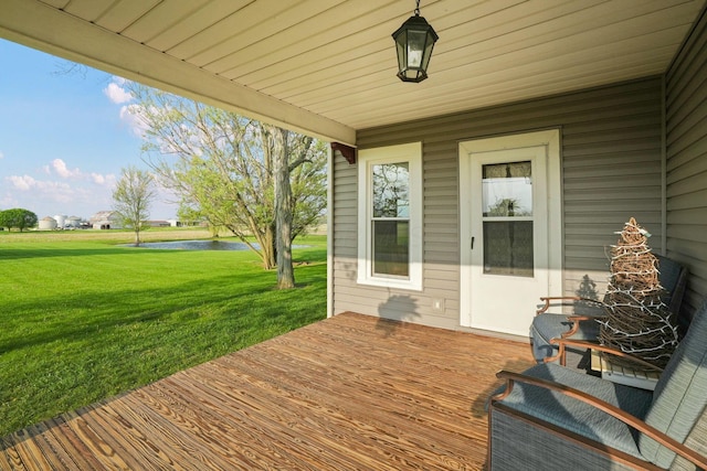 wooden terrace featuring a yard and a water view