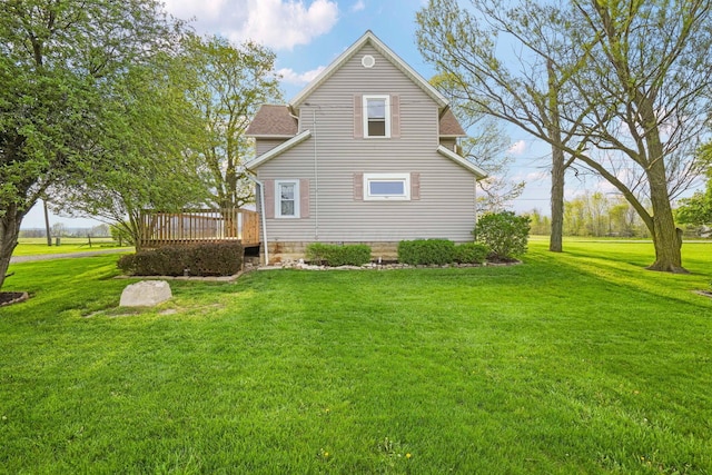 rear view of property with a lawn and a deck