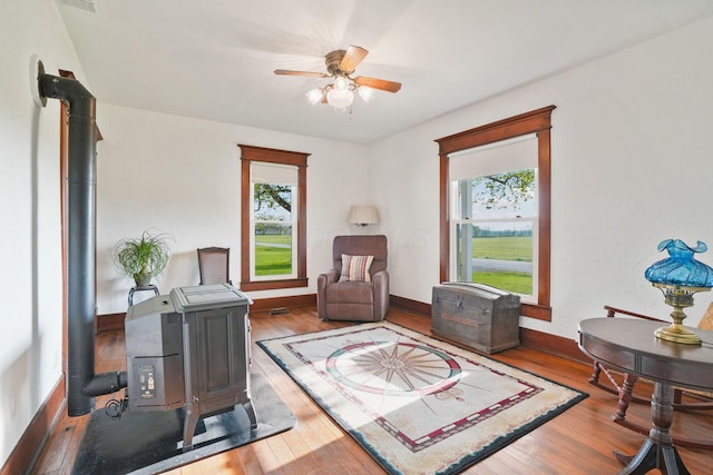 living area with plenty of natural light, baseboards, ceiling fan, and wood finished floors