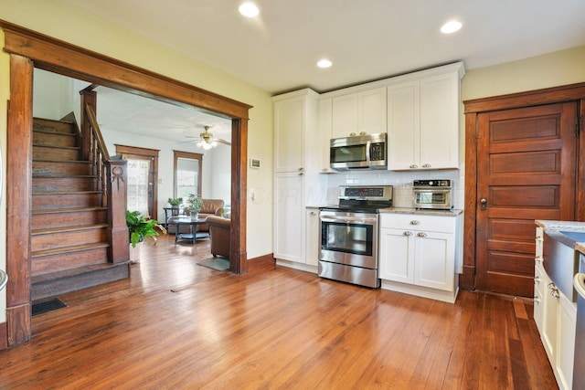kitchen featuring light wood-style floors, recessed lighting, white cabinets, backsplash, and stainless steel appliances