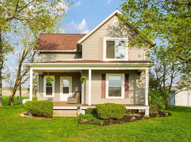 back of property featuring a porch, a lawn, and roof with shingles