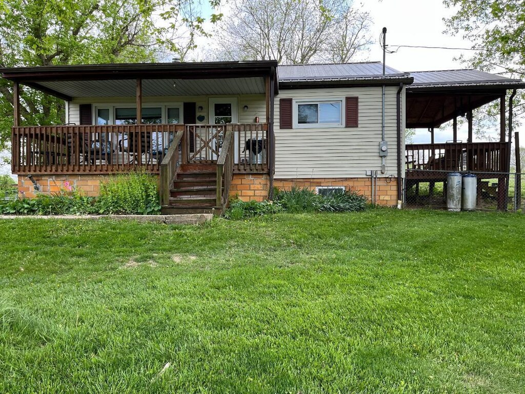 back of house with a yard, metal roof, and covered porch
