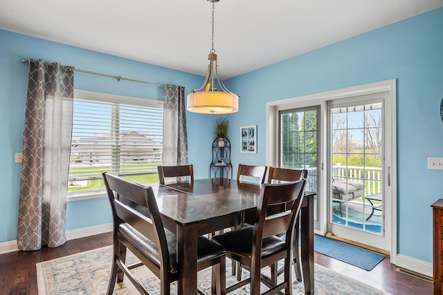 dining room featuring baseboards, plenty of natural light, wood finished floors, and visible vents