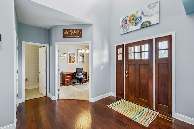 foyer featuring baseboards, dark wood-style flooring, and visible vents