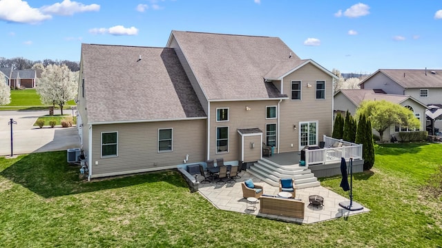 rear view of house featuring a residential view, a deck, a patio area, and central AC