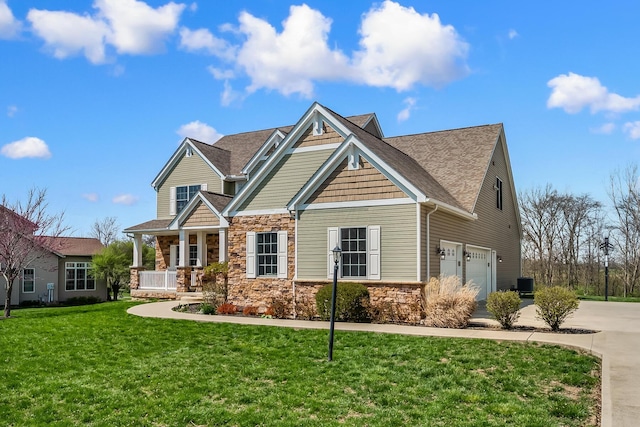 craftsman inspired home featuring stone siding, a garage, a porch, a front yard, and driveway