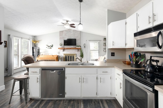 5756 Idana Ct, Westerville, OH 43081 - kitchen featuring a peninsula, a ceiling fan, a sink, appliances with stainless steel finishes, and vaulted ceiling