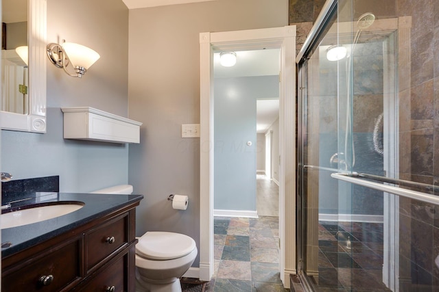 full bathroom with vanity, baseboards, a shower stall, and toilet