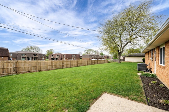 view of yard with a residential view, central AC unit, and a fenced backyard