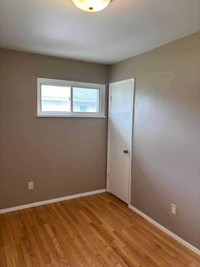 spare room with light wood-style floors and baseboards