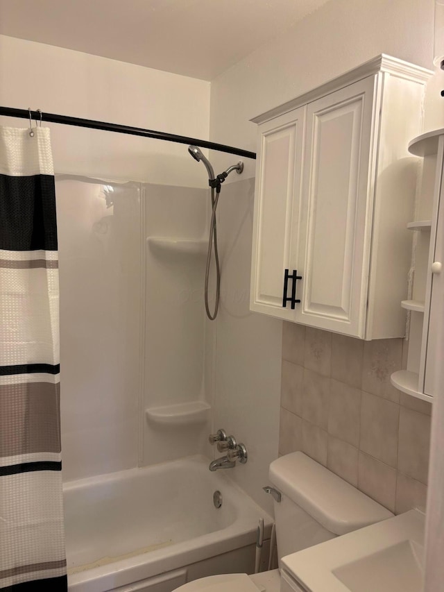 bathroom featuring shower / bathtub combination with curtain and toilet