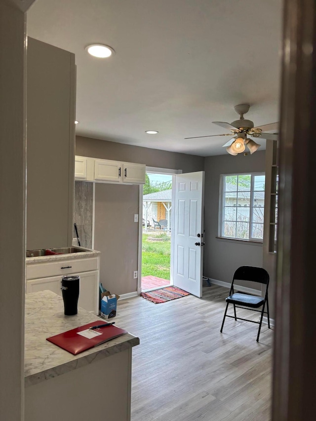 entryway with a healthy amount of sunlight, baseboards, and light wood-type flooring