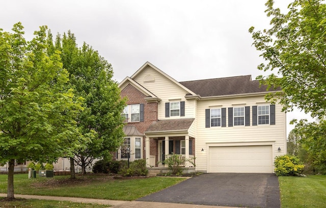 traditional-style house with an attached garage, a front lawn, driveway, and brick siding