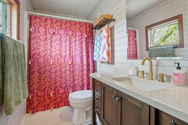 bathroom featuring vanity, tile patterned flooring, curtained shower, toilet, and a textured ceiling