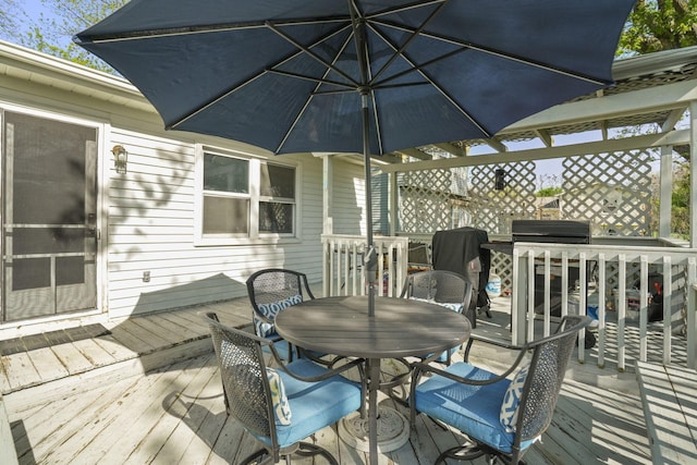 deck featuring outdoor dining area and a grill