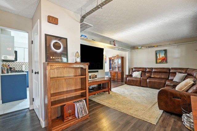 living room with a textured ceiling and dark wood-type flooring