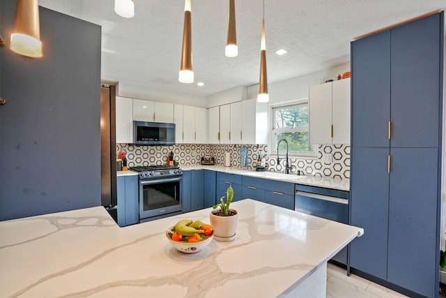 kitchen with a sink, blue cabinetry, backsplash, and stainless steel appliances