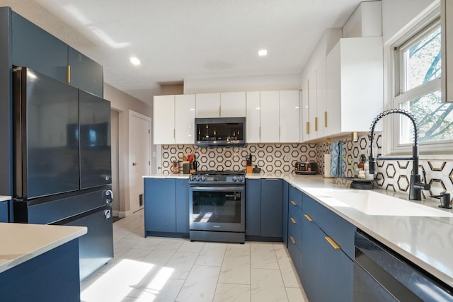 kitchen with light countertops, blue cabinets, a sink, and stainless steel appliances