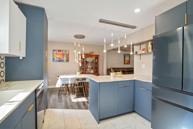kitchen featuring freestanding refrigerator, marble finish floor, a peninsula, and light stone countertops