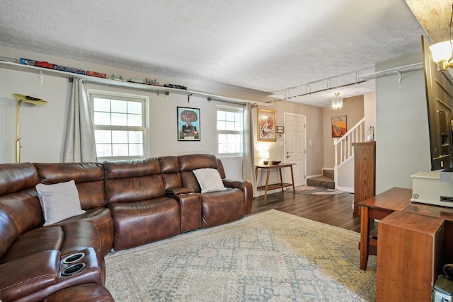 living room featuring stairs, a textured ceiling, and wood finished floors