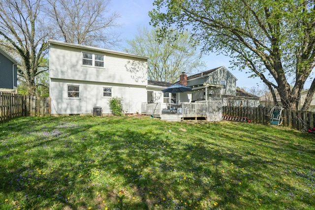 rear view of house with a lawn, cooling unit, a wooden deck, and a fenced backyard