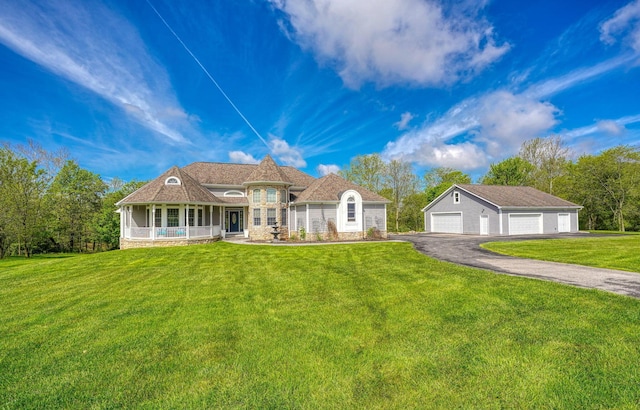 2051 River Rd, Delaware, OH 43015 - view of front of property with a detached garage, a front lawn, an outbuilding, and covered porch