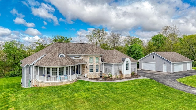 2051 River Rd, Delaware, OH 43015 - view of front of house with stone siding, a garage, an outdoor structure, a front yard, and a porch