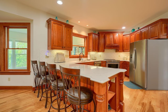 2051 River Rd, Delaware, OH 43015 - kitchen with stainless steel appliances, a sink, a peninsula, light wood-style floors, and recessed lighting