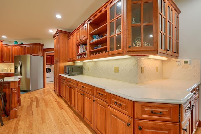 2051 River Rd, Delaware, OH 43015 - kitchen with stainless steel refrigerator with ice dispenser, washer / dryer, light countertops, light wood-style floors, and recessed lighting