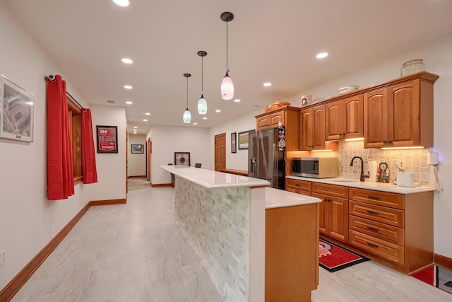 2051 River Rd, Delaware, OH 43015 - kitchen featuring appliances with stainless steel finishes, a sink, a kitchen island, light countertops, and baseboards