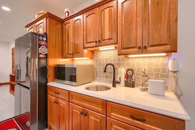 2051 River Rd, Delaware, OH 43015 - kitchen featuring appliances with stainless steel finishes, a sink, backsplash, light countertops, and brown cabinets