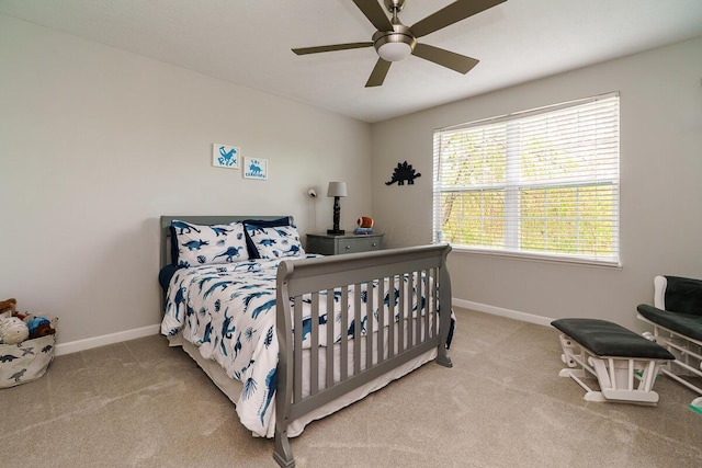 carpeted bedroom featuring baseboards and ceiling fan