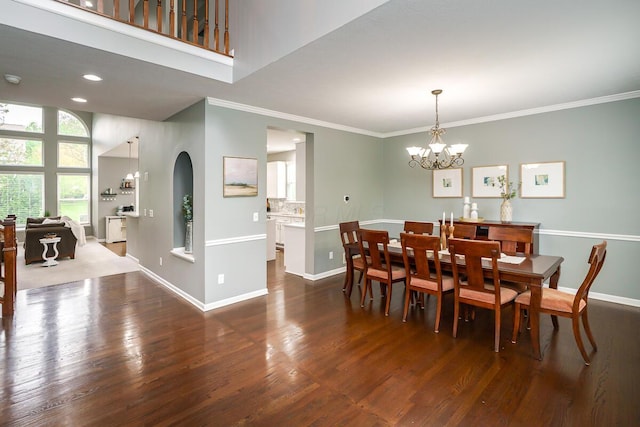 dining space with arched walkways, baseboards, a chandelier, and dark wood finished floors