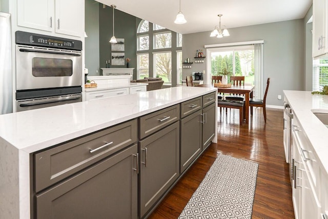 kitchen with gray cabinets, decorative light fixtures, a notable chandelier, white cabinetry, and dark wood-type flooring