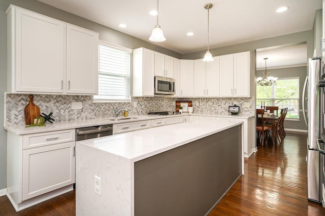 kitchen featuring an inviting chandelier, light countertops, white cabinetry, backsplash, and stainless steel appliances
