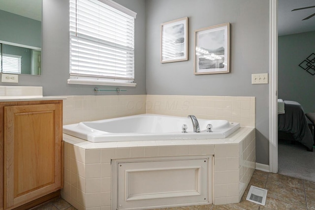 ensuite bathroom with visible vents, vanity, a bath, tile patterned floors, and ensuite bath