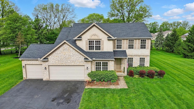 1775 Harrison Pond Dr, New Albany, OH 43054 - view of front facade with stone siding, stucco siding, a shingled roof, and asphalt driveway