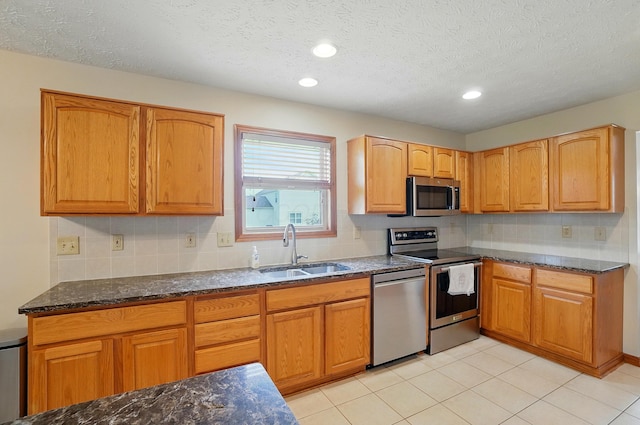1775 Harrison Pond Dr, New Albany, OH 43054 - kitchen with appliances with stainless steel finishes, a sink, dark stone counters, tasteful backsplash, and a textured ceiling