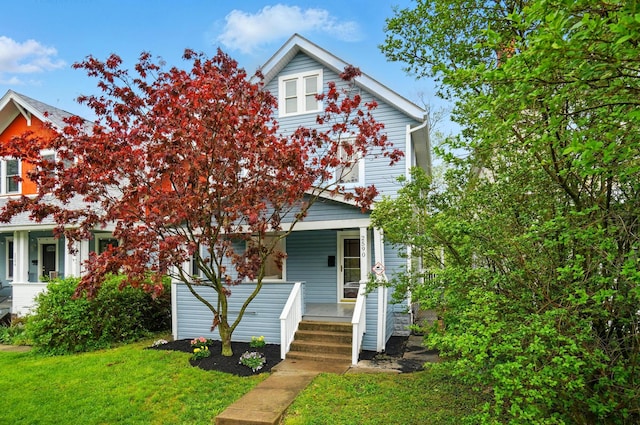 view of front of home with a porch and a front lawn