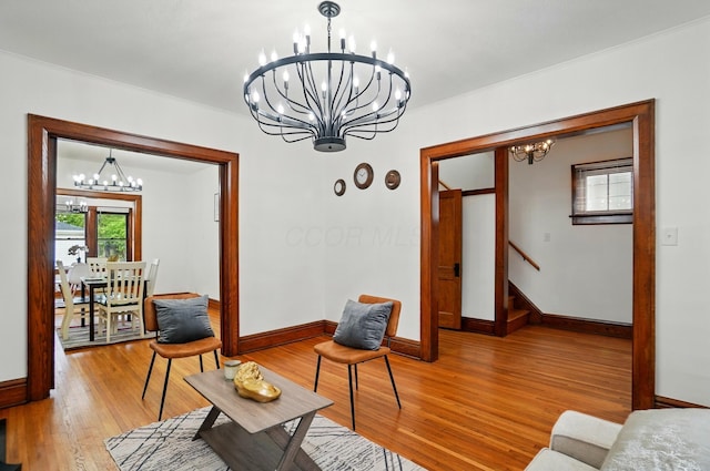 living area featuring crown molding, baseboards, and an inviting chandelier