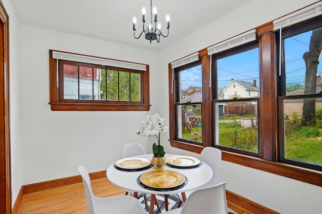 dining room featuring baseboards, a chandelier, and light wood-type flooring