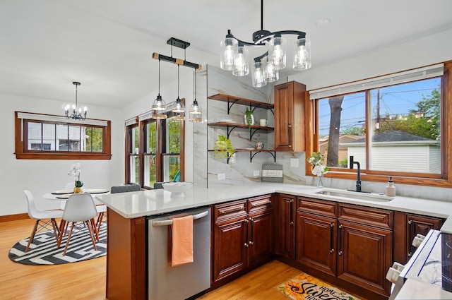 kitchen featuring a sink, a healthy amount of sunlight, light wood-type flooring, and a chandelier