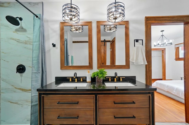 bathroom featuring a sink, double vanity, and a shower