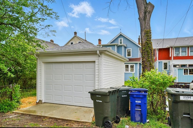 view of front of house with a garage and an outbuilding