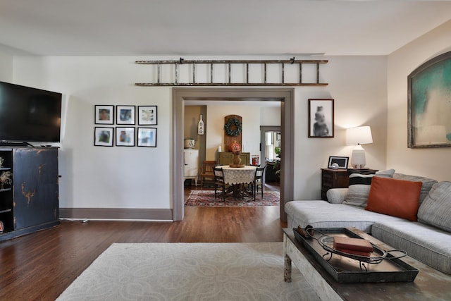 living area with baseboards and wood finished floors