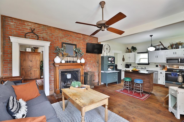 living room with dark wood-style flooring, ceiling fan, and a fireplace