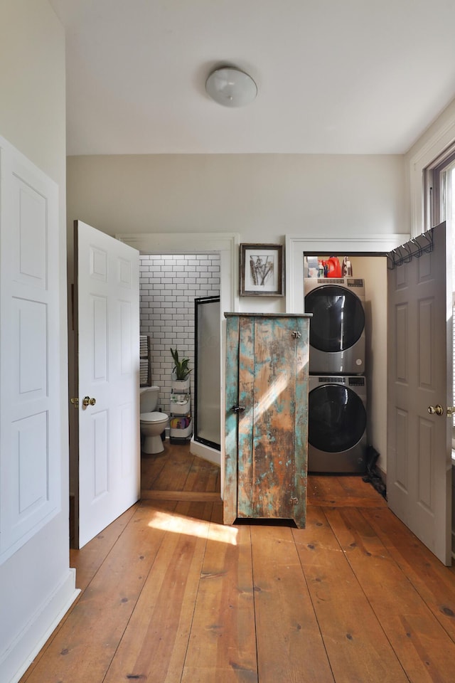 interior space with wood-type flooring and stacked washer and dryer