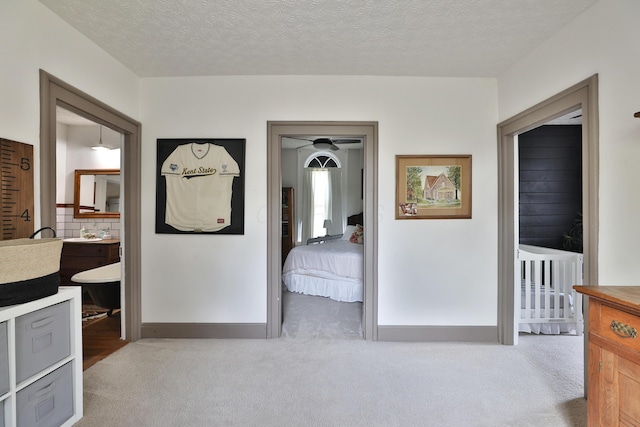 corridor with carpet floors and a textured ceiling